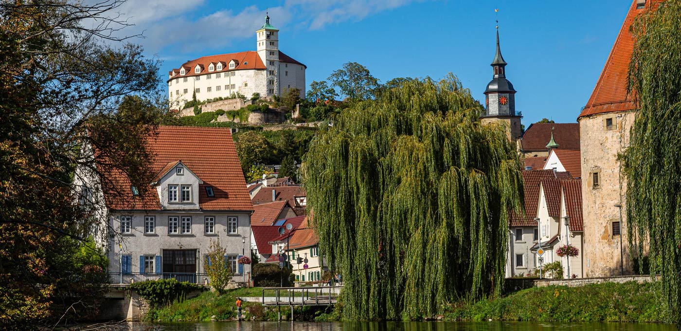 Ansicht der historischen Altstadt von Vaihingen an der Enz, mit traditionellen Fachwerkhäusern und der Enz. Im Hintergrund das Wahrzeichen der Stadt, Schloss Kaltenstein, auf dem Hügel über dem Stadtkern.